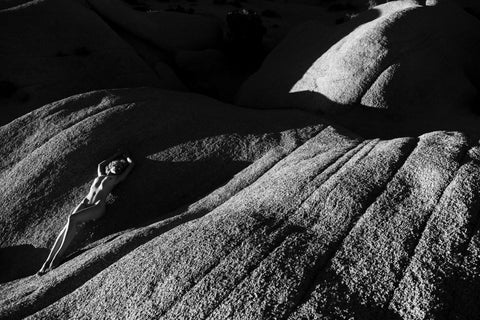 a black and white photograph, showing a nude model posing on a rock in joshua tree national park, California - by Thomas Haensgen