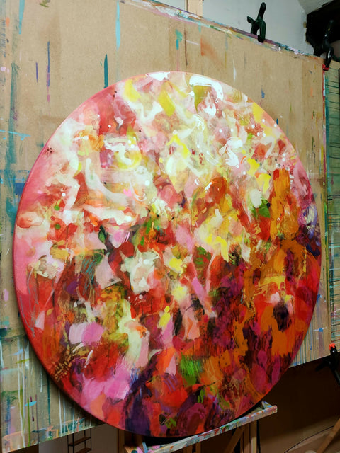 Colourful abstract painting by contemporary artist Krisztina Megyeri, featuring warm reds and expressive layers of colour on a round canvas diameter 100cm